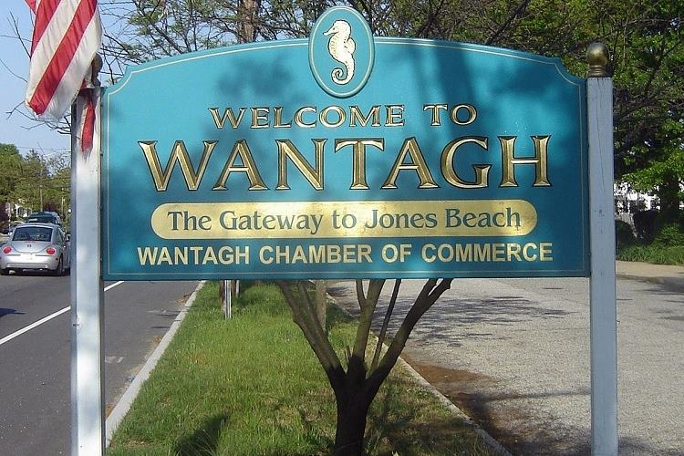 Sign in Wantagh, New York reads 'Welcome to Wantagh - The Gateway to Jones Beach' with adjacent American flag