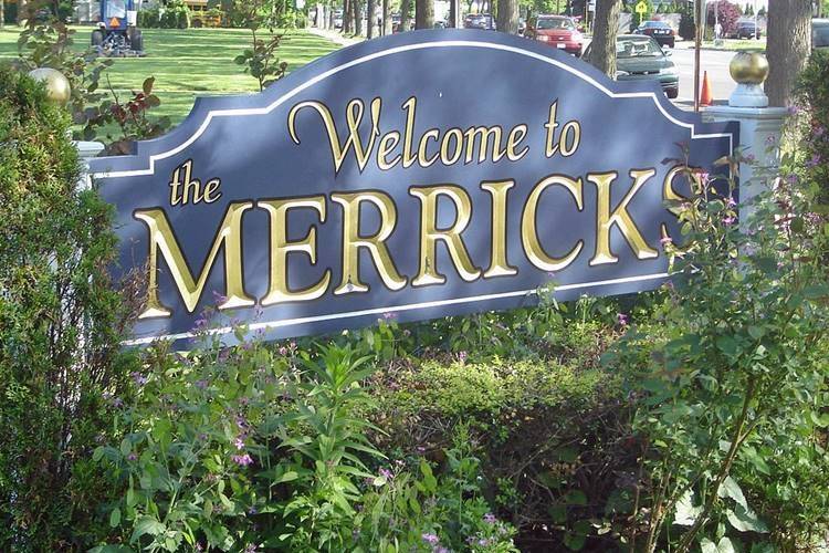 Outdoor sign welcoming visitors to Merrick, New York surrounded by plants