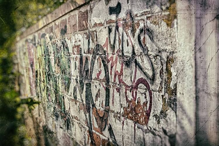 Outdoor concrete block wall covered in grafitti
