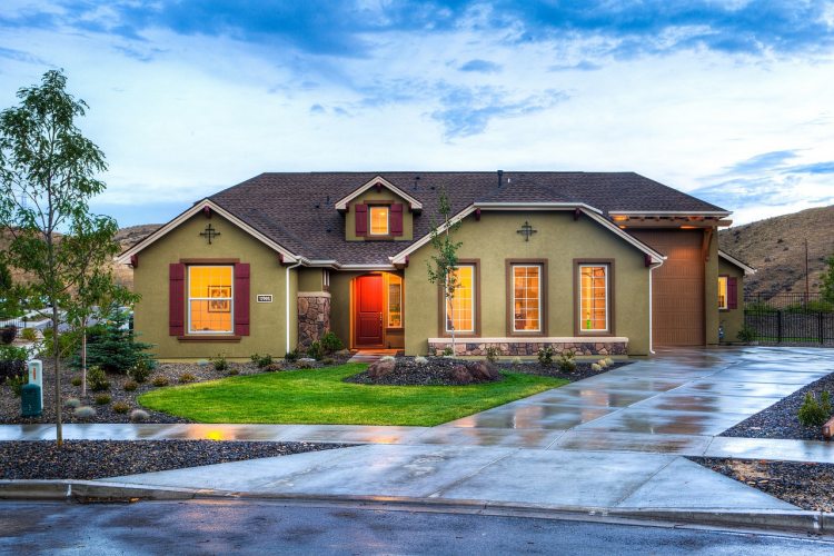 Suburban home with red front door and wet concrete driveway