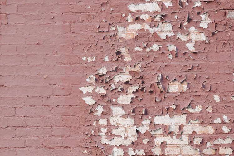 Brick wall with crumbling salmon paint